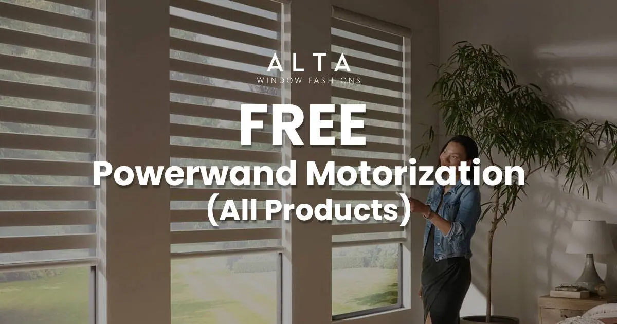 Woman standing near large window with blinds, promoting free Powerwind motorization for all products by ALTA Window Fashions.