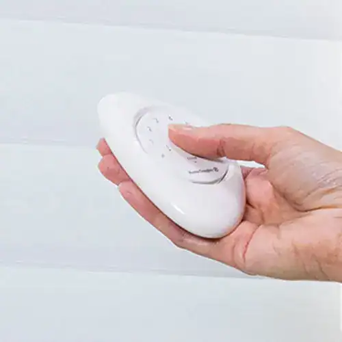 Remote control being used to operate window blinds or drapery for easy sunlight and privacy management.