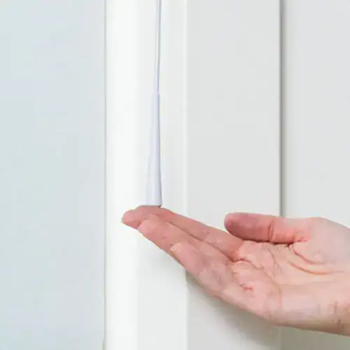 Smooth white window blind or shade with hand pointing at the blind for demonstration.