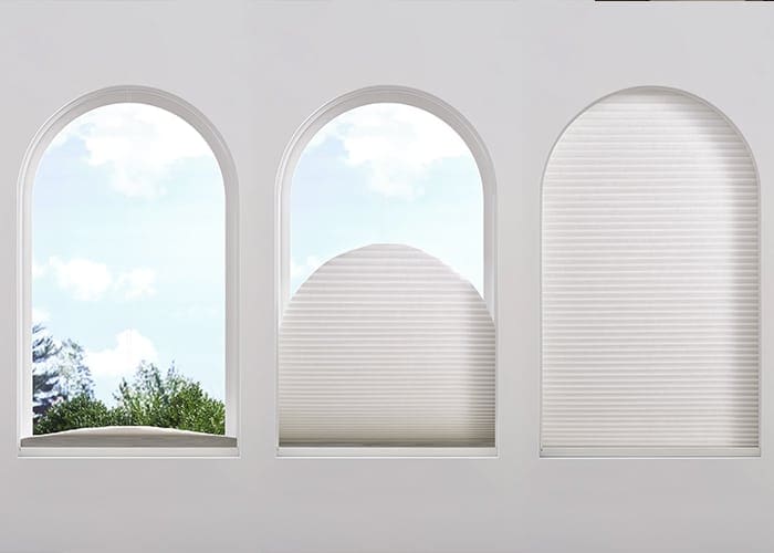 Roll-up window blinds on white arched windows for privacy and light control, featuring custom window coverings from Blinds West.