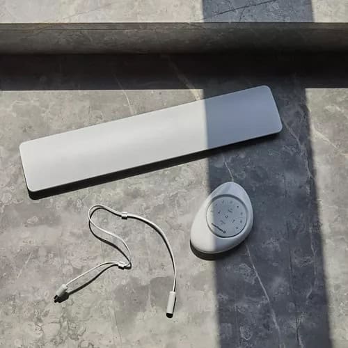 Wireless remote control device and accessory for smart window blinds and drapery systems in modern home interior.