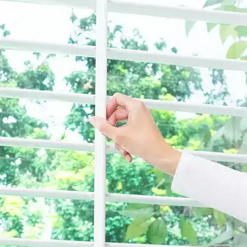 Adjustable white plantation shutters for interior window coverage for home or office decor.