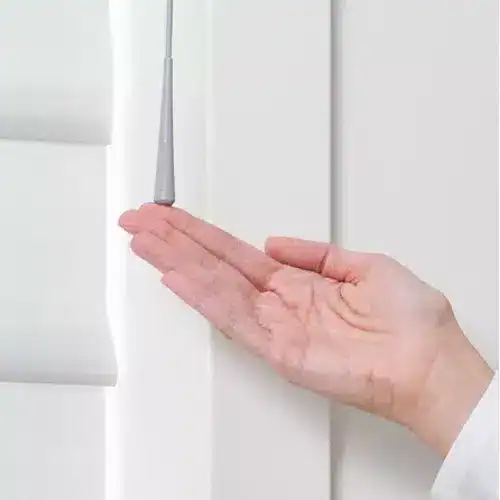 Comfortable hand cleaning a white window blind with a cloth and duster, showcasing high-quality window covering maintenance.